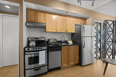 a kitchen with a stove and a refrigerator at RivetStays - The Pantages Suite in Toronto
