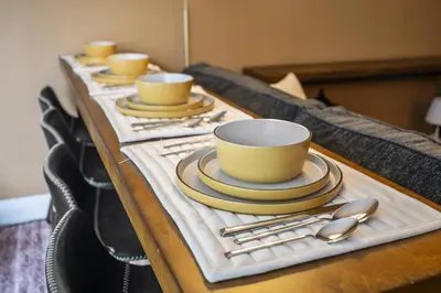 a table with yellow cups and plates and spoons at RivetStays - The Pantages Suite in Toronto
