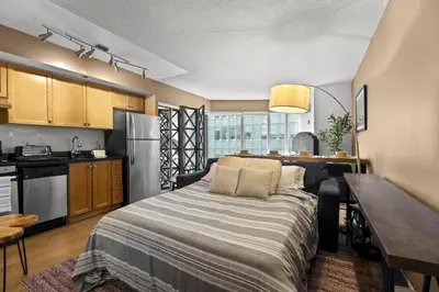 a kitchen and living room with a bed in a room at RivetStays - The Pantages Suite in Toronto