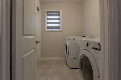 a laundry room with a washing machine and a window at 4Bed25 BathBrand newNiagara FallsSleeps12 in Thorold