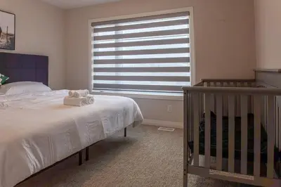 a bedroom with a bed and a large window at 4Bed25 BathBrand newNiagara FallsSleeps12 in Thorold