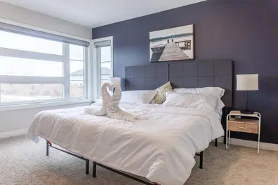 a bedroom with a large bed with white sheets at 4Bed25 BathBrand newNiagara FallsSleeps12 in Thorold