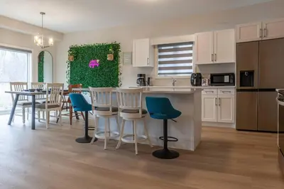 a kitchen and dining room with a table and chairs at 4Bed25 BathBrand newNiagara FallsSleeps12 in Thorold