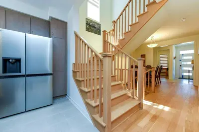 a kitchen and dining room with a staircase and a refrigerator at Brand New 7beds-kingbedsfamilysleep15playtable in Milton