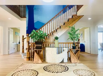 a living room with a wooden staircase and a blue ceiling at Amazing Unique House in Richmond Hill in Richmond Hill