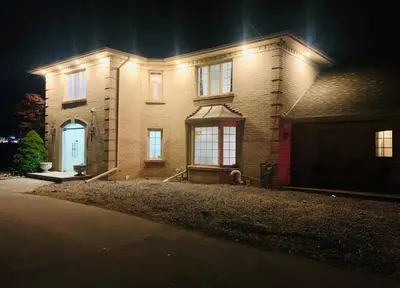 a brick house with a red door at night at Amazing Unique House in Richmond Hill in Richmond Hill