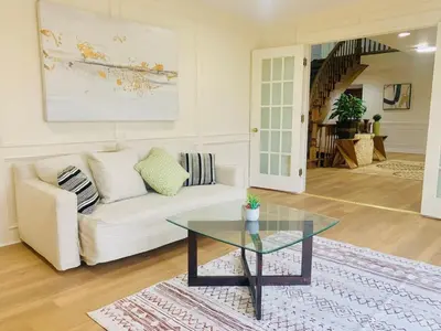 a living room with a white couch and a glass table at Amazing Unique House in Richmond Hill in Richmond Hill