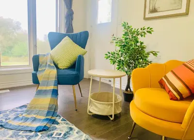 a living room with two chairs and a table at Amazing Unique House in Richmond Hill in Richmond Hill