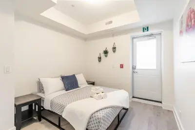 a bedroom with a bed with a teddy bear on it at Westend Suites - Beautifully Furnished 3BR Apartment Close to High Park in Toronto