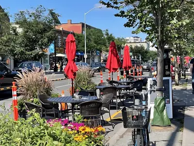 a group of tables and chairs with red umbrellas at Westend Suites - Beautifully Furnished 3BR Apartment Close to High Park in Toronto