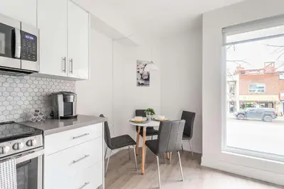a kitchen with a table and chairs and a window at Westend Suites - Beautifully Furnished 3BR Apartment Close to High Park in Toronto