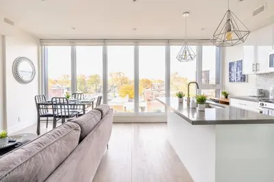 a kitchen and living room with a couch and a table at Westend Suites - Contemporary 3BR with Natural Light High Park North in Toronto