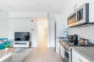 a kitchen and living room with a couch and a table at Westend Suites - Stylish 3BR Condo near High Park Trails in Toronto
