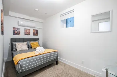 a bedroom with a bed and two windows at Westend Suites - Modern 1BR Apartment - 8min walk to High Park in Toronto