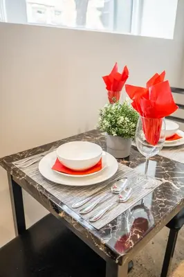 a table with plates and glasses and red napkins at Westend Suites - Modern 1BR Apartment - 8min walk to High Park in Toronto