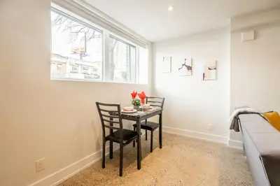 a dining room with a table and two chairs at Westend Suites - Modern 1BR Apartment - 8min walk to High Park in Toronto