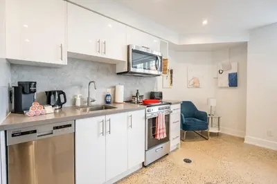 a kitchen with white cabinets and a sink at Westend Suites - Modern 1BR Apartment - 8min walk to High Park in Toronto