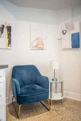 a blue chair sitting in a room with a table at Westend Suites - Modern 1BR Apartment - 8min walk to High Park in Toronto