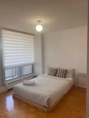 a bedroom with a large bed with a window at The Charming Downtown Stop in Toronto