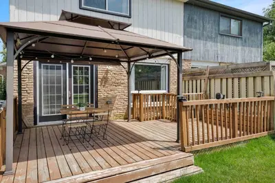 a wooden deck with a table and an umbrella at Family 4BDR 2BA with Basement in Mississauga in Mississauga