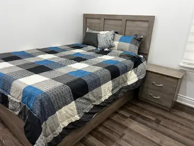 a bedroom with a bed with a checkered blanket at Three Bedroom Spacious Bangalow with Free Parking, closer to commercial area and highways in Mississauga