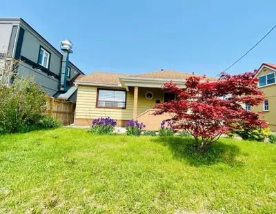 a yellow house with a red tree in a yard at Three Bedroom Spacious Bangalow with Free Parking, closer to commercial area and highways in Mississauga
