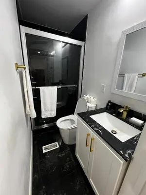 a black and white bathroom with a toilet and a sink at Three Bedroom Spacious Bangalow with Free Parking, closer to commercial area and highways in Mississauga