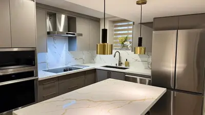 a kitchen with stainless steel appliances and a counter at Luxury 2-Bedroom Designer Suite Richmond Hill Lake Wilcox in Richmond Hill