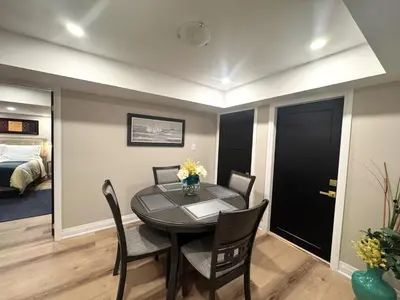 a dining room with a table and chairs and a bedroom at Luxury 2-Bedroom Designer Suite Richmond Hill Lake Wilcox in Richmond Hill