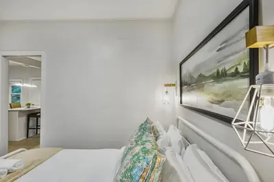 a bedroom with a bed with a painting on the wall at Chic 2 BR Urban Retreat Near Beach Free Parking in Oshawa