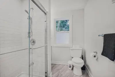 a white bathroom with a shower and a toilet at Chic 2 BR Urban Retreat Near Beach Free Parking in Oshawa