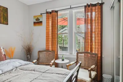 a bedroom with two chairs and a bed and a window at Ora's Place BNB in Niagara Falls