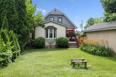 a house with a bench in front of a yard at Ora's Place BNB in Niagara Falls