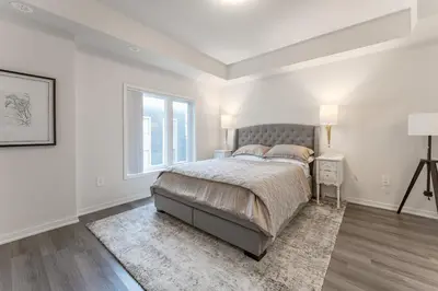 a white bedroom with a bed and a window at Luxury Townhouse in Vaughan in Vaughan