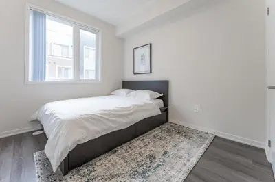 a white bedroom with a bed and a window at Luxury Townhouse in Vaughan in Vaughan