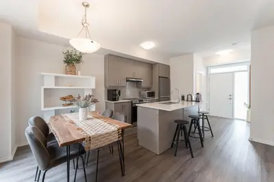 a kitchen and living room with a table and chairs at Luxury Townhouse in Vaughan in Vaughan