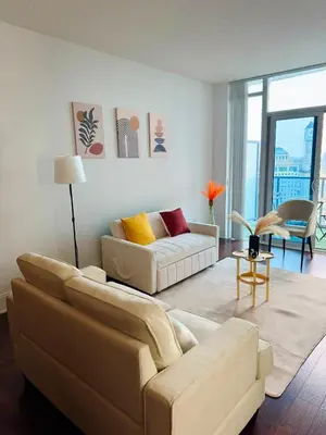 a living room with a couch and a table at Modern One Bedroom Near Square One With Free Parking in Mississauga