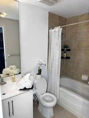 a bathroom with a toilet and a sink and a tub at Modern One Bedroom Near Square One With Free Parking in Mississauga