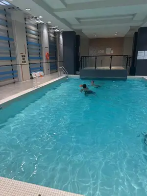a person swimming in a large swimming pool at Modern One Bedroom Near Square One With Free Parking in Mississauga