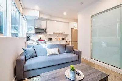 a living room with a blue couch and a table at Chic 2BR Basement Suite 2BR Toronto Getaway near Downtown - The Roland in Toronto