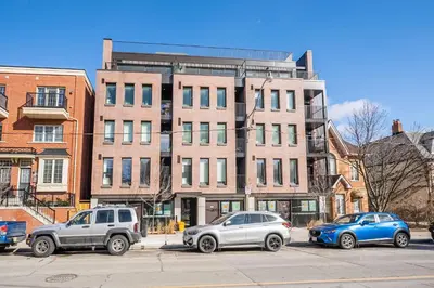 three cars parked in a parking lot in front of a building at Chic 2BR Basement Suite 2BR Toronto Getaway near Downtown - The Roland in Toronto