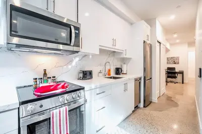 a kitchen with a stove and a microwave at Inviting 2BR Basement Suite in Downtown Toronto - The Roland in Toronto