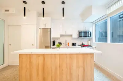 a kitchen with a wooden island in the middle at Peaceful 2BR Basement Suite Near Downtown Toronto - The Roland in Toronto