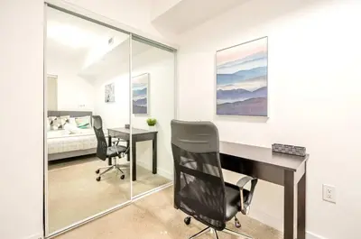 a bedroom with a desk and two chairs and a bed at Peaceful 2BR Basement Suite Near Downtown Toronto - The Roland in Toronto