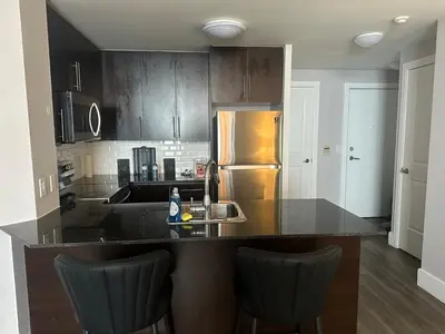 a kitchen with a counter and a refrigerator at Stylish 2BR Suite by Square One in Mississauga