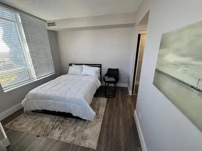 a bedroom with a bed and a painting on the wall at Stylish 2BR Suite by Square One in Mississauga