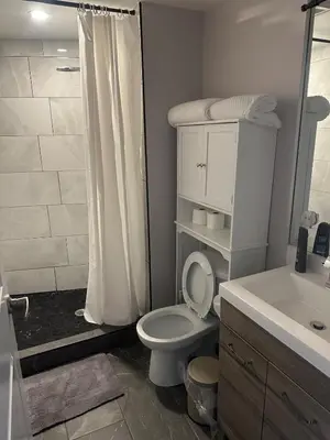 a bathroom with a toilet and a sink and a shower at Stylish 2BR Suite by Square One in Mississauga