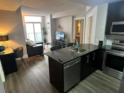 a kitchen and living room with a counter top at Stylish 2BR Suite by Square One in Mississauga