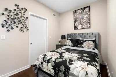 a bedroom with a bed with a black and white comforter at Luxury Lakeview Downtown Condo, CN Tower, Rogers Center, Scotia Arena, Lake View with Free Parking in Toronto