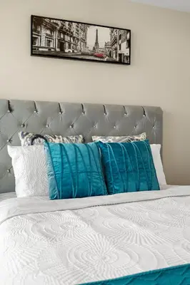 a bed with blue pillows on top of it at Luxury Lakeview Downtown Condo, CN Tower, Rogers Center, Scotia Arena, Lake View with Free Parking in Toronto